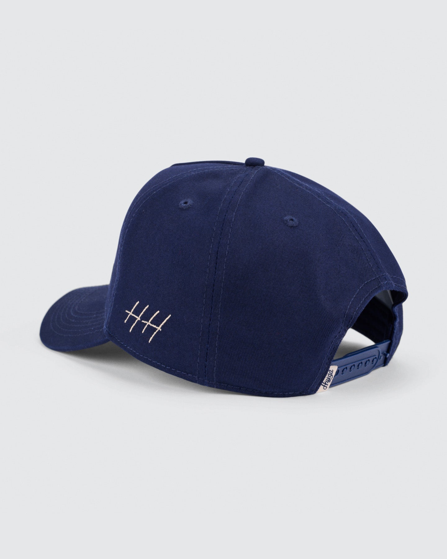 Navy blue cap with a small white logo on a light gray background
