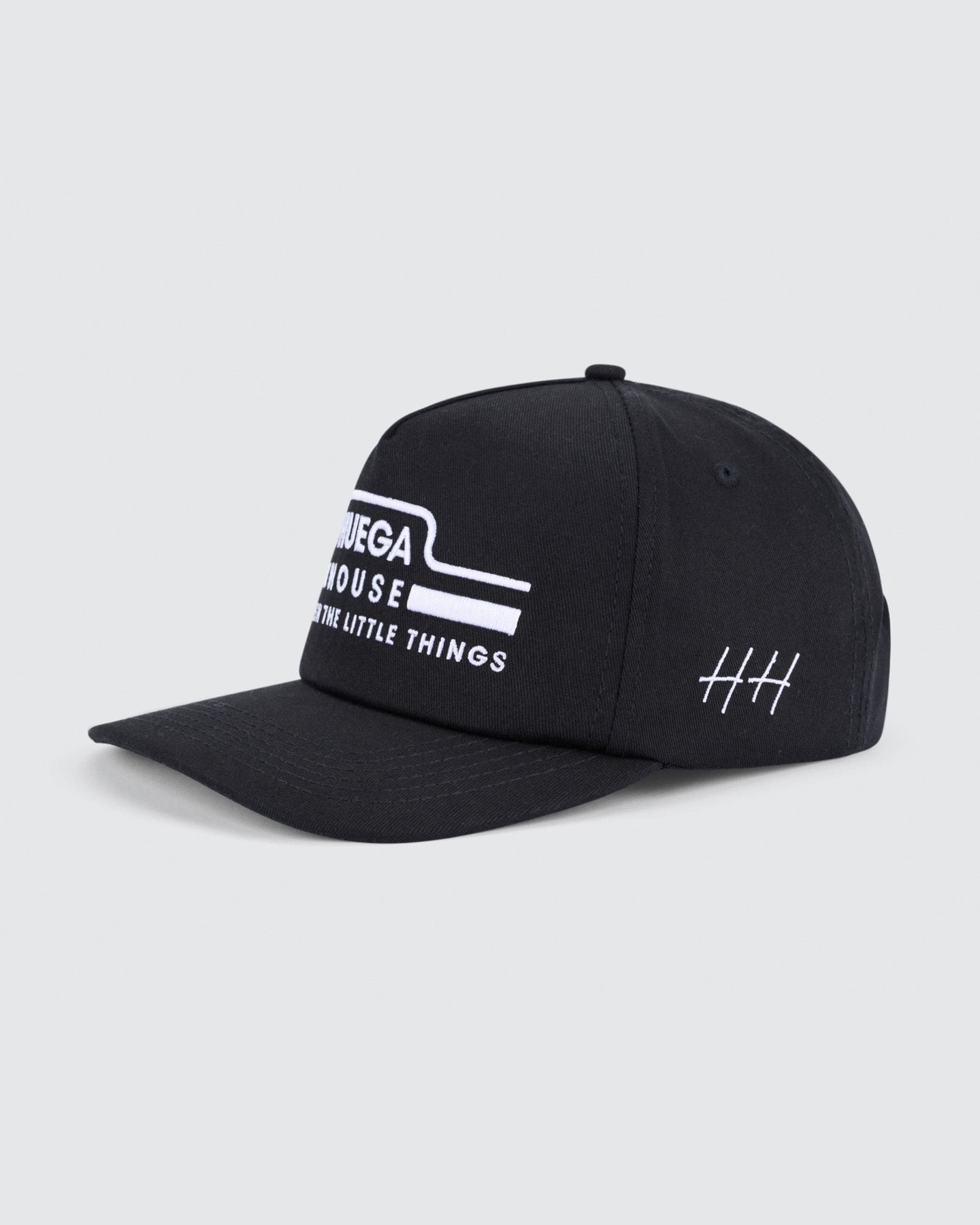 Black cap with white text and logo on a light gray background